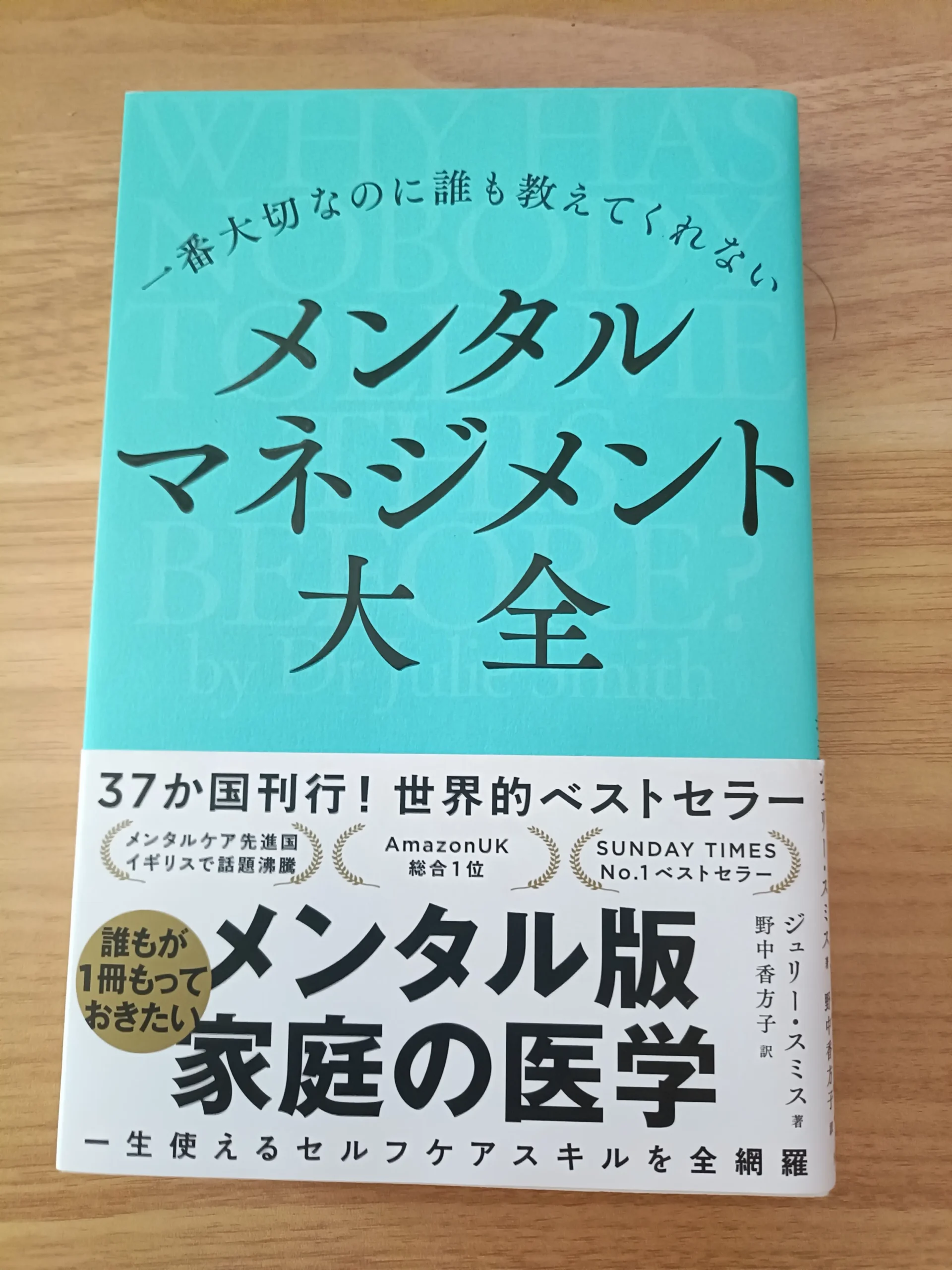 木の机に置いた『一番大切なのに誰も教えてくれない メンタルマネジメント大全』の表紙