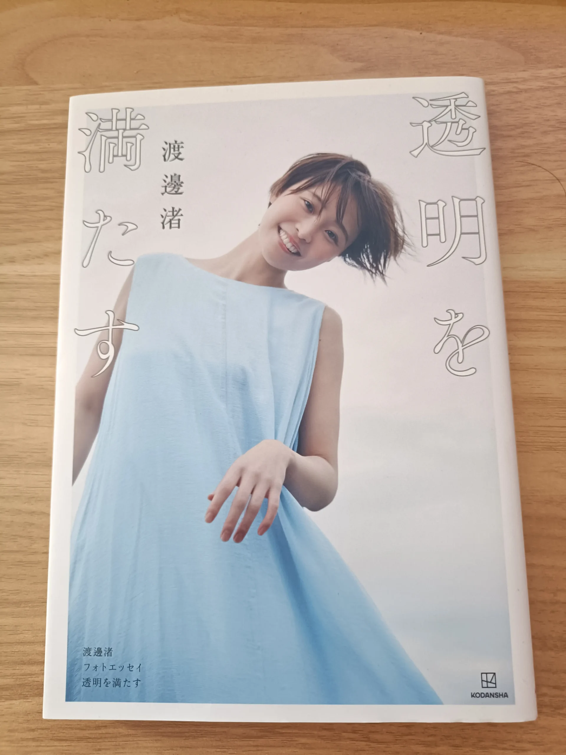 木の机に置いた渡邊渚著『透明を満たす』の表紙