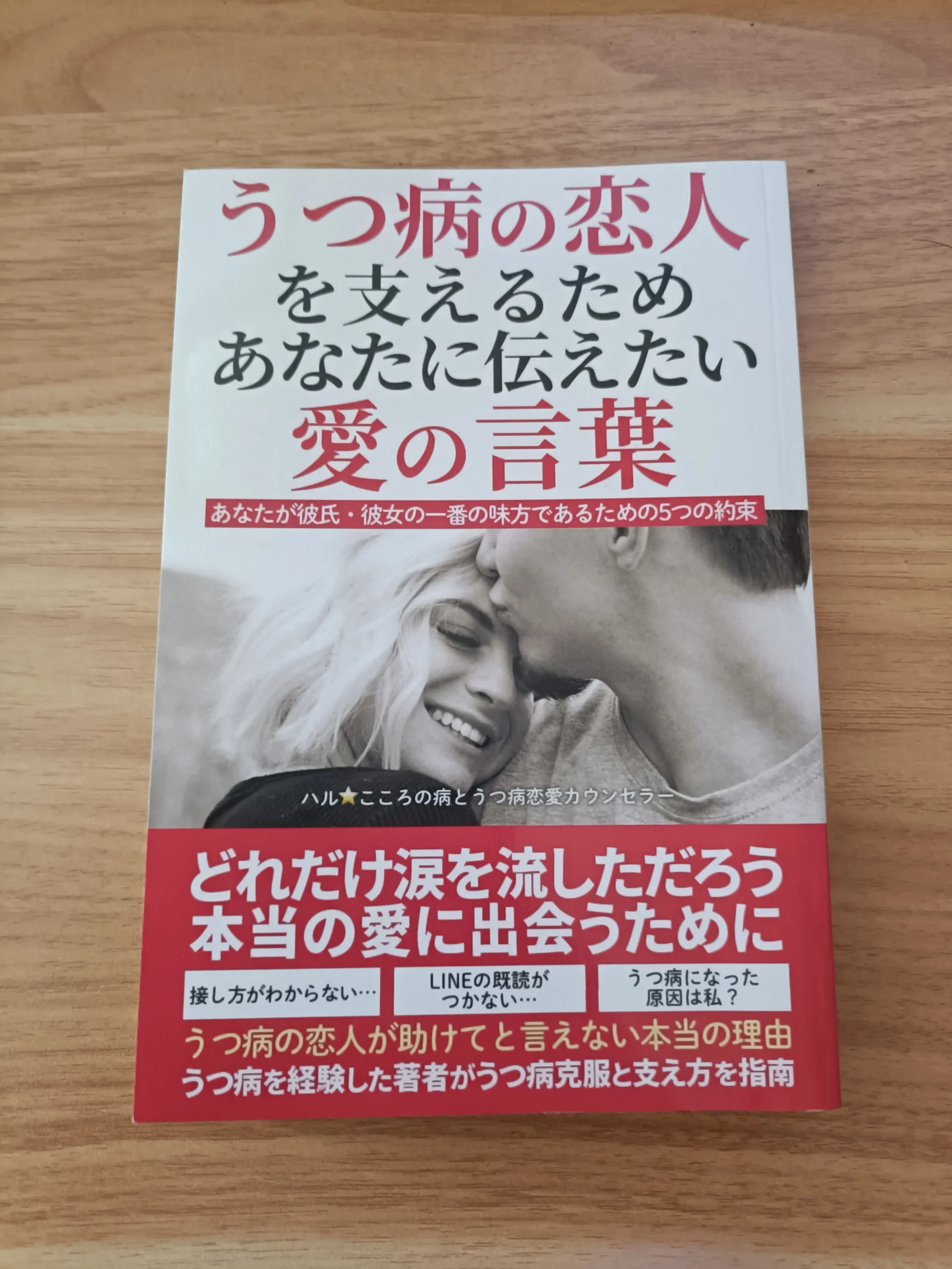 木の机に置いた『うつ病の恋人を支えるためあなたに伝えたい愛の言葉』の表紙