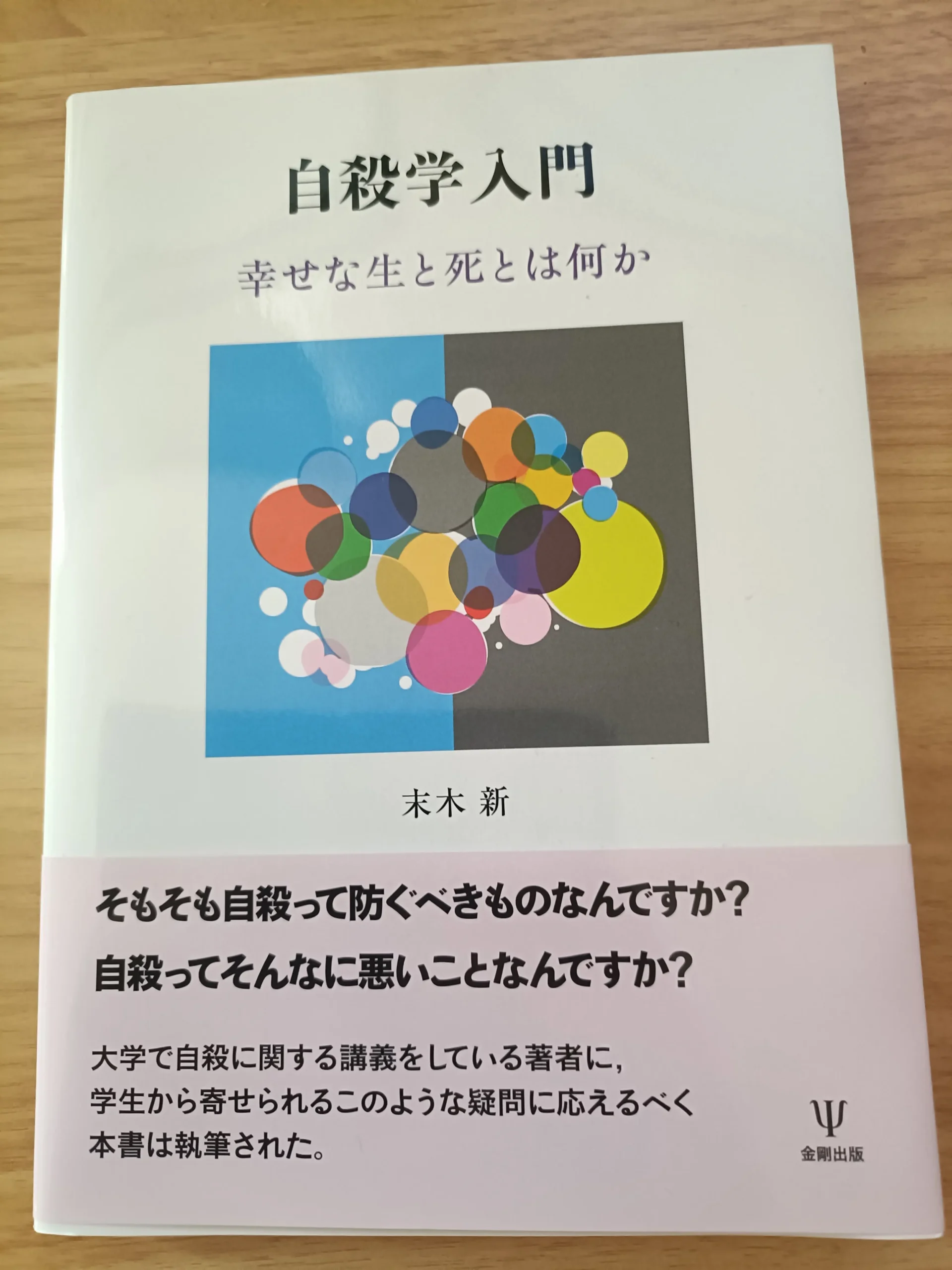 木の机に置いた末木新著『自殺学入門』の表紙